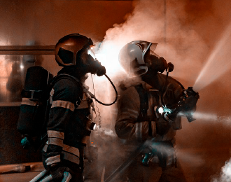 two firefighters extinguishing a fire